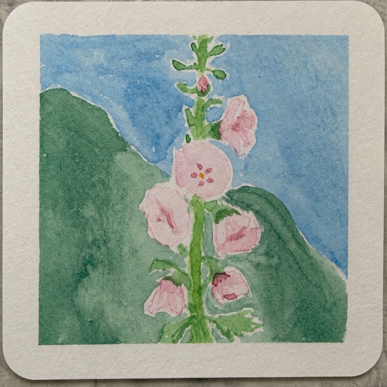 青空と緑の山を背景に、ピンクの花が咲く水彩イラスト